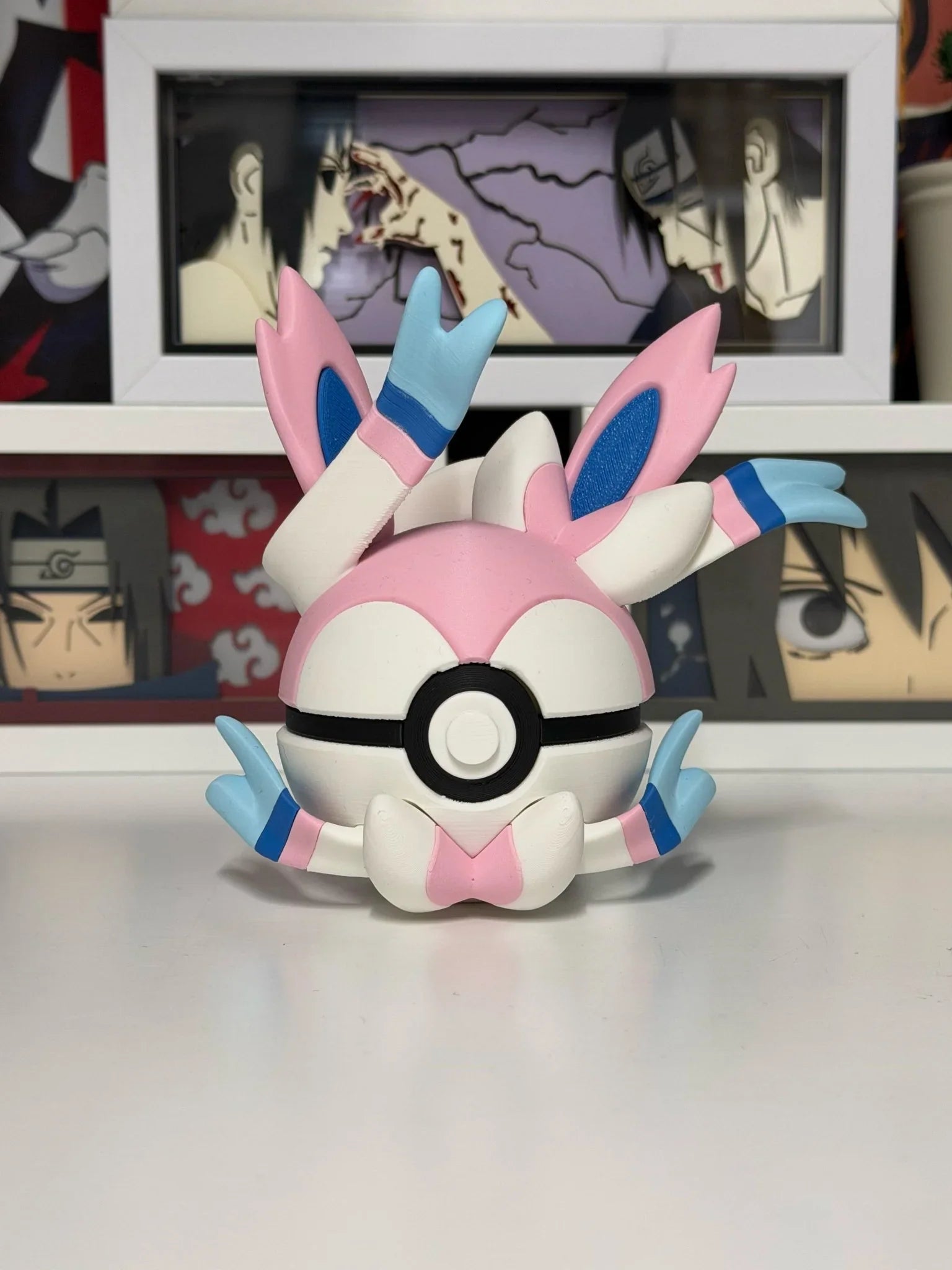 Pokeball personalizzata ispirata a Sylveon, decorata con fiocchi rosa e dettagli azzurri, su sfondo anime.