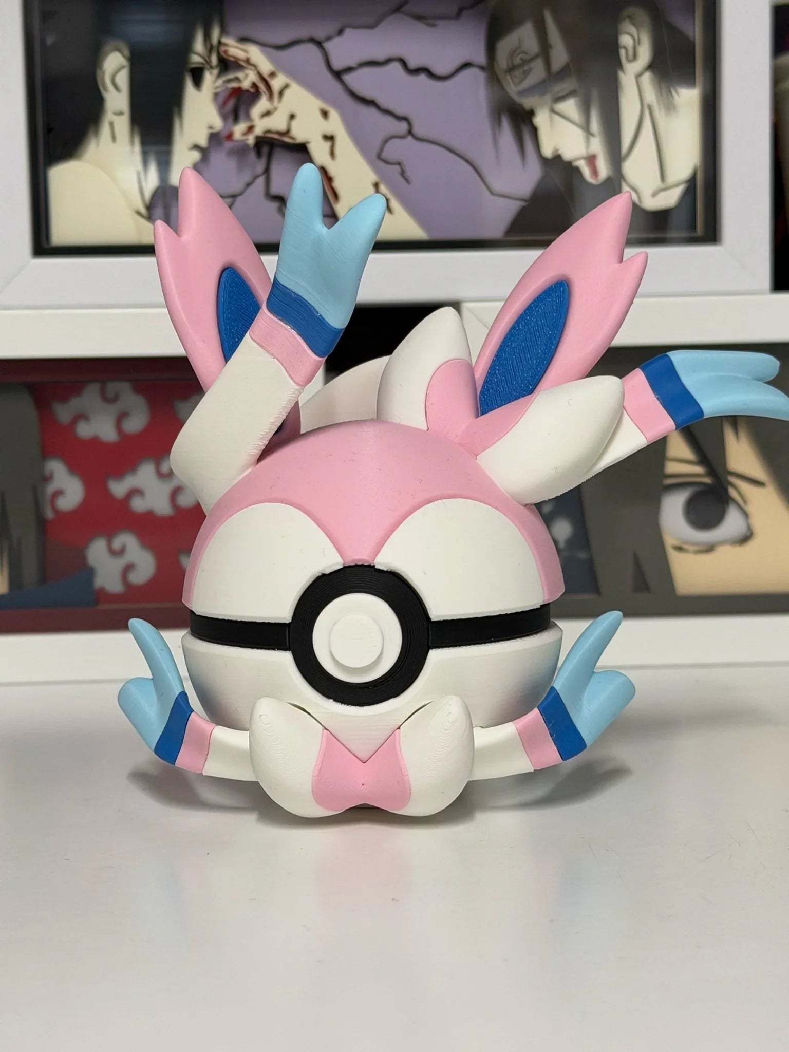 Pokeball Sylveon decorativa rosa e bianca, stile anime, su sfondo con cornici manga.