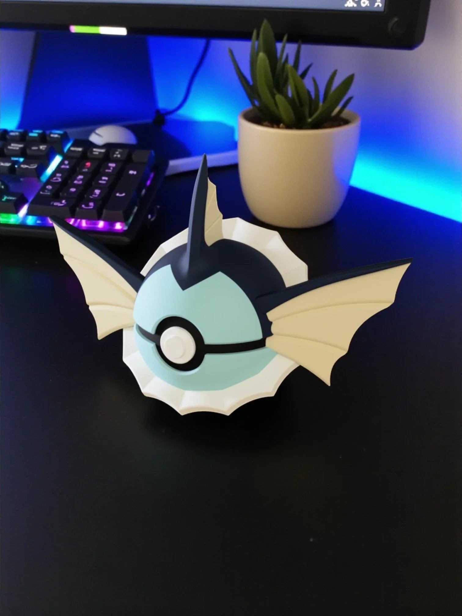 Pokeball ispirata a Vaporeon con base magnetica su scrivania, tastiera RGB e pianta sullo sfondo