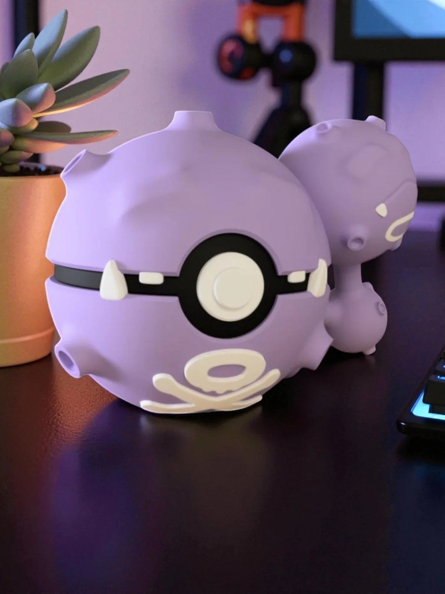 Pokeball viola ispirata a Weezing su scrivania, decorazione geek anime