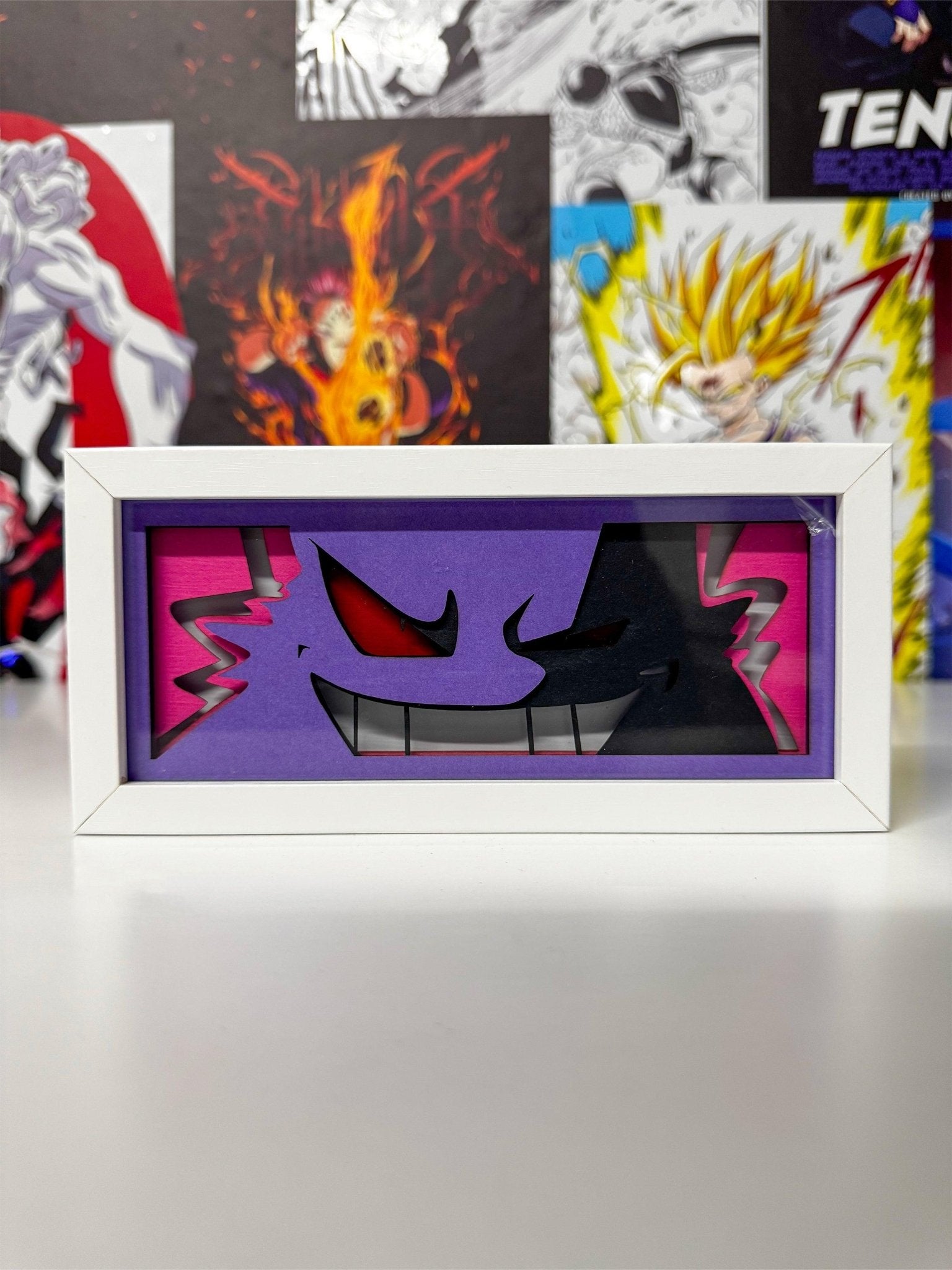 Light box decorativo con Gengar Pokémon, cornice bianca, sfondo viola, stile anime.