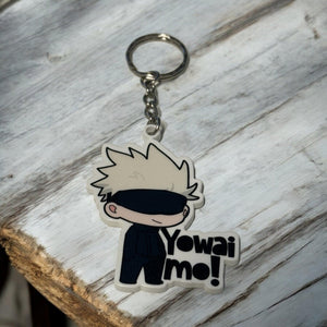 Portachiavi anime Satoru Gojo Jujutsu Kaisen in stile chibi con scritta Yowai mo su legno chiaro.