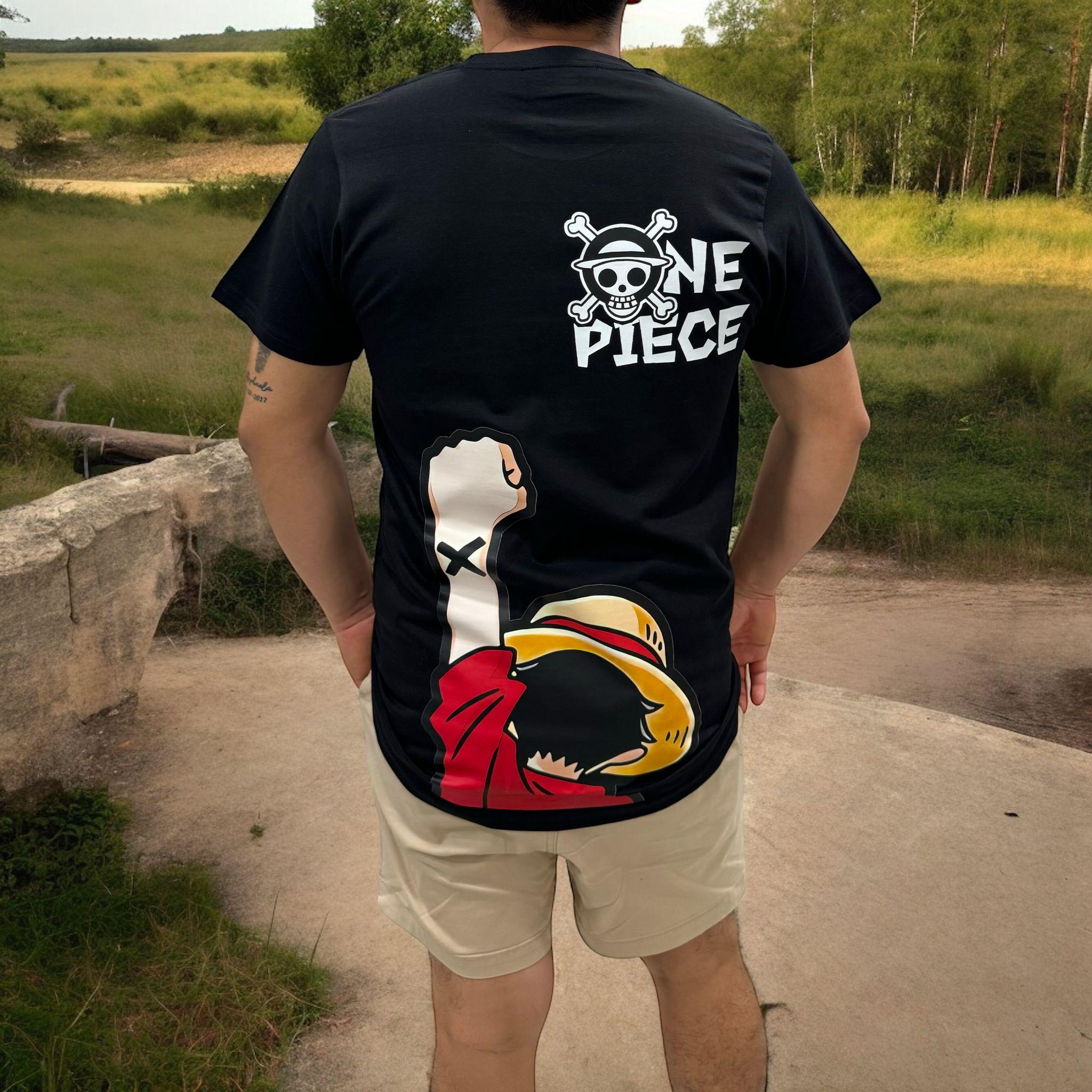 Ragazzo con t-shirt nera One Piece raffigurante Luffy e logo sul retro, all'aperto