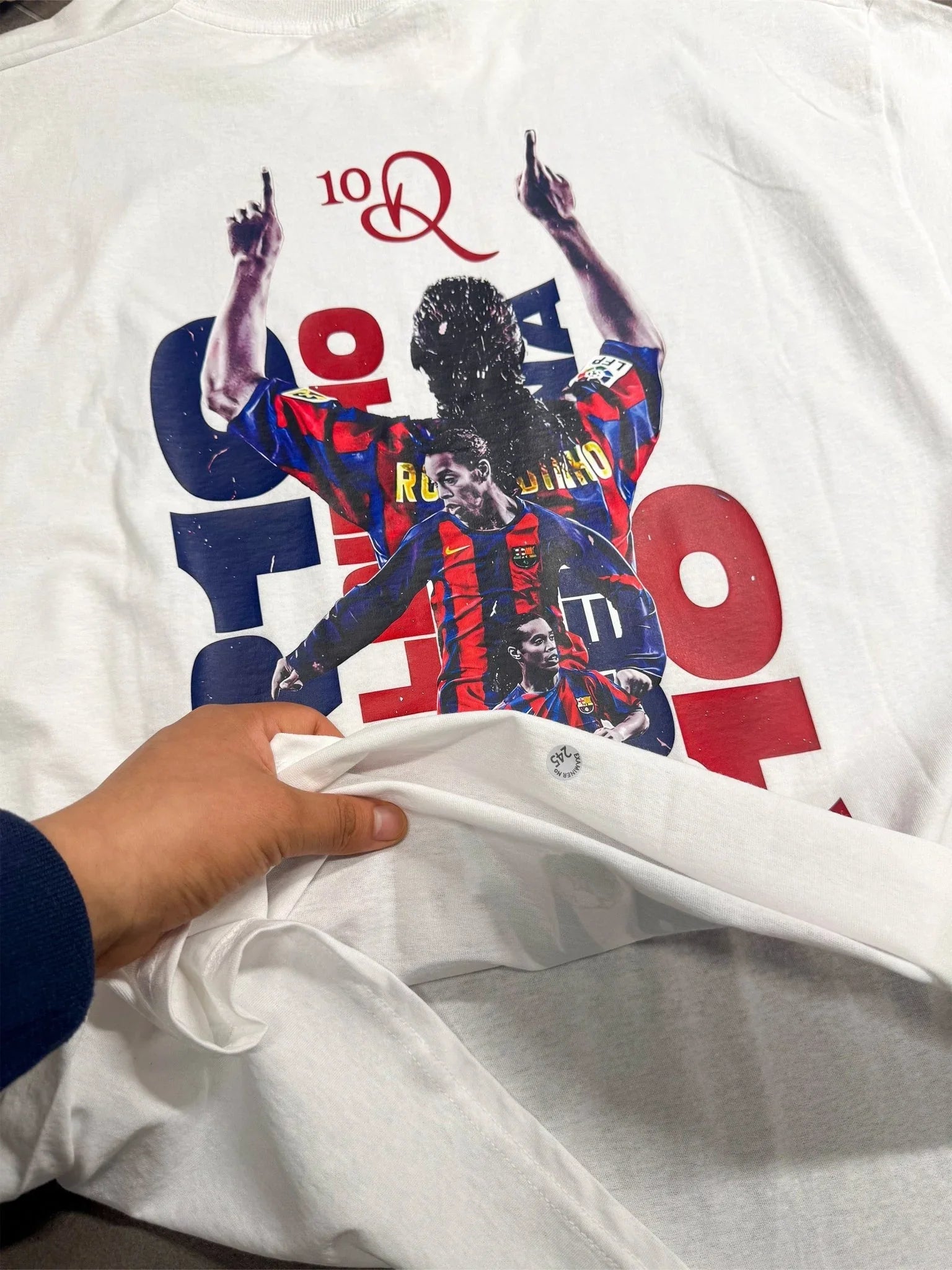 T-shirt bianca con stampa oversize di calciatore in maglia blaugrana, dettaglio sulla spalla.
