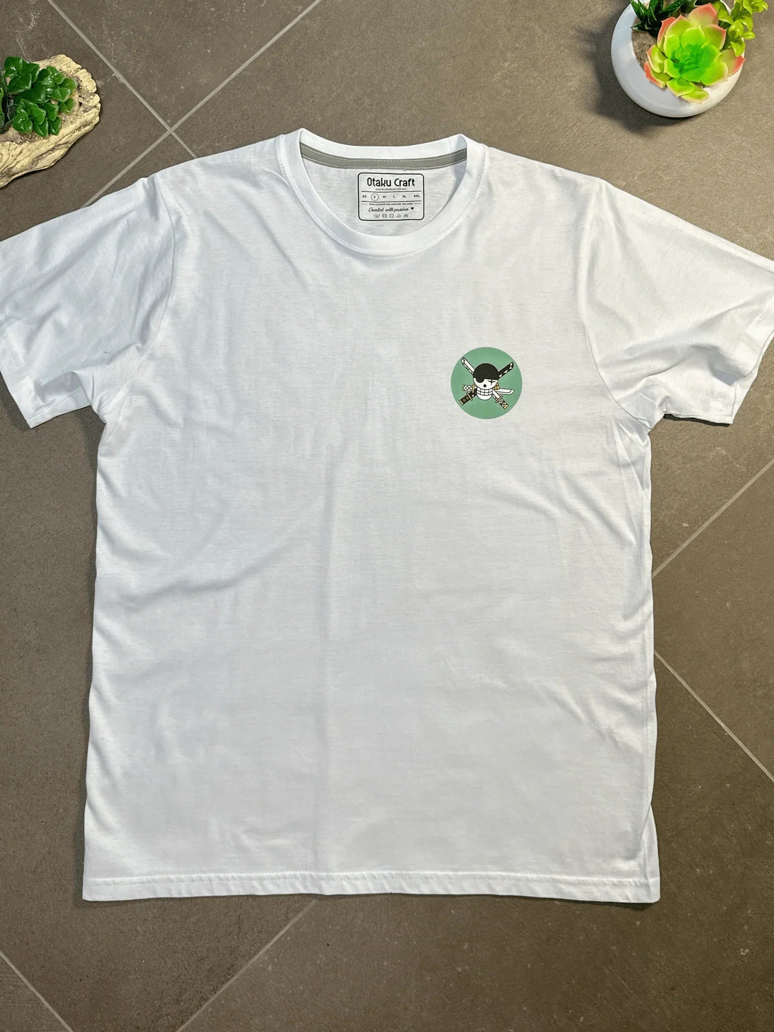 T-shirt bianca con ricamo Zoro Roronoa One Piece, dettaglio stilizzato in verde
