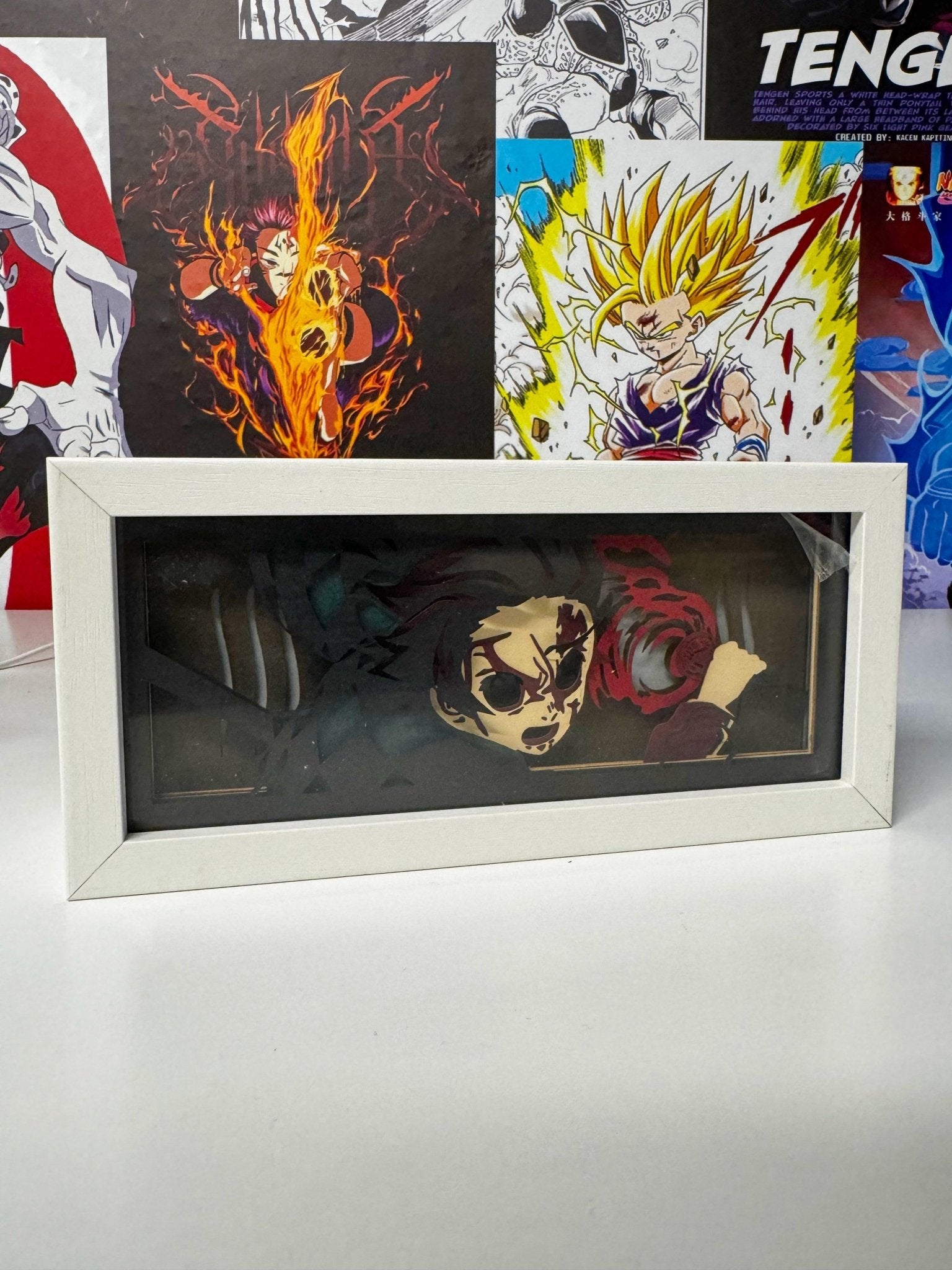 Lampada LED light box con personaggio anime Tanjiro in cornice bianca, poster manga sullo sfondo