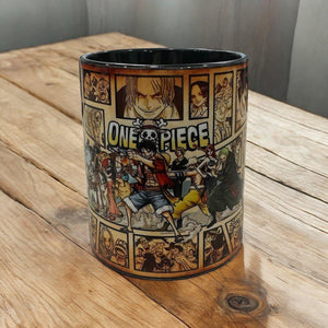 Tazza con illustrazioni dei personaggi di One Piece e logo sulla superficie, su tavolo di legno.