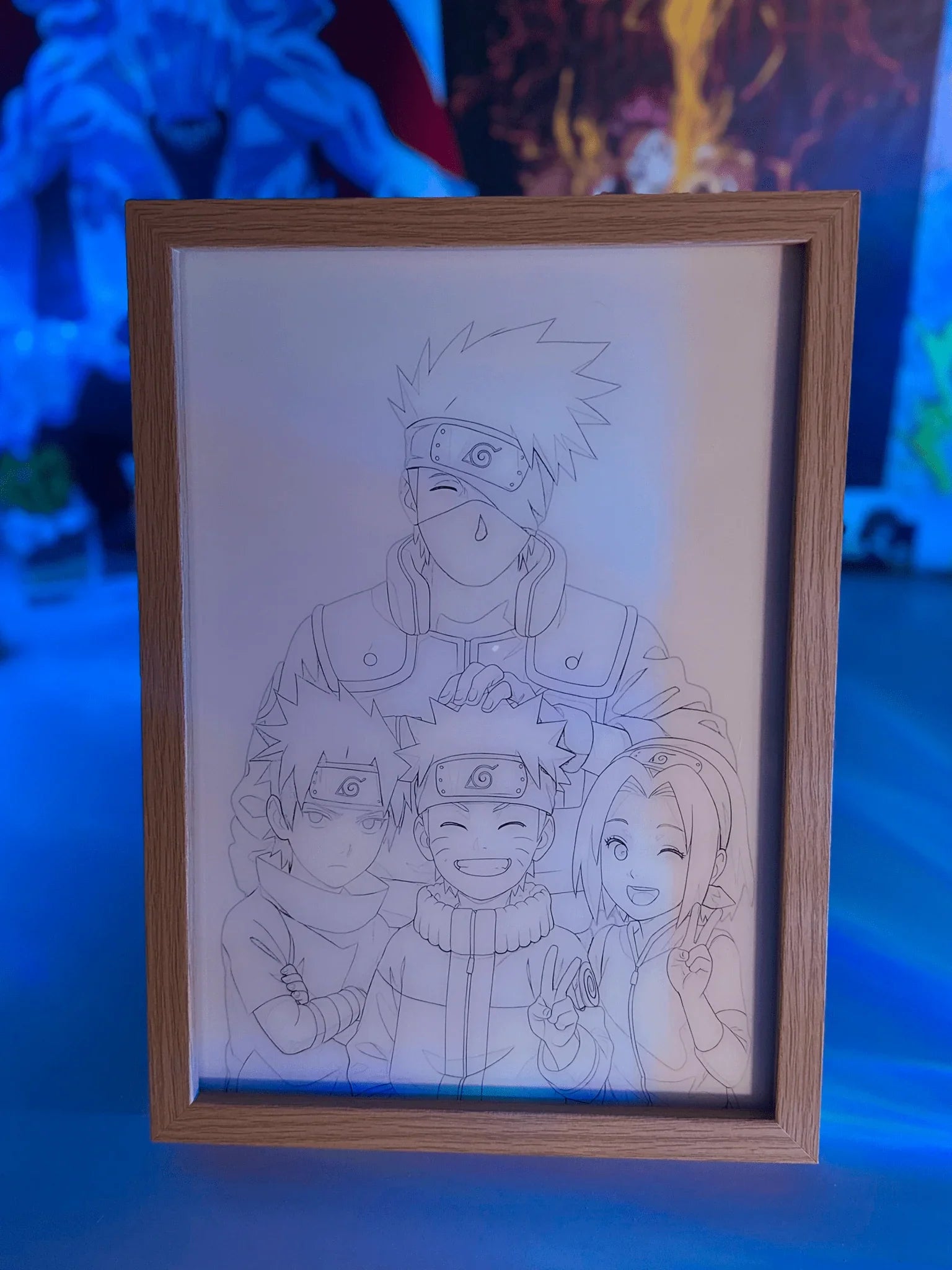 Quadro LED con disegno Team 7 di Naruto, cornice legno, sfondo blu, stile anime.